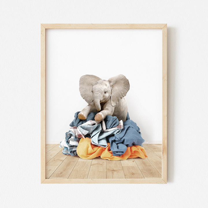 an elephant sitting on top of a pile of clothes