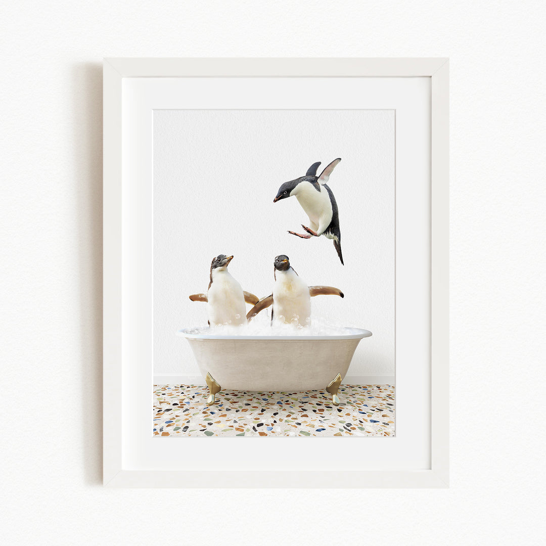 A framed image depicting two penguins sitting in a bathtub, with one penguin flying towards the other penguin.