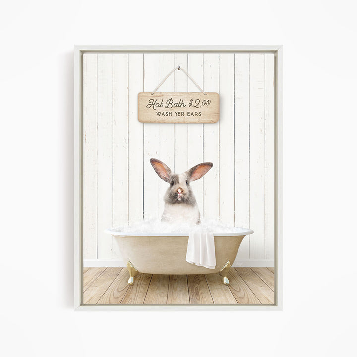 A white rabbit sitting in a bathtub filled with water, with a wooden sign above it that reads "Hot Bath $2.00 WASH YOUR EARS".