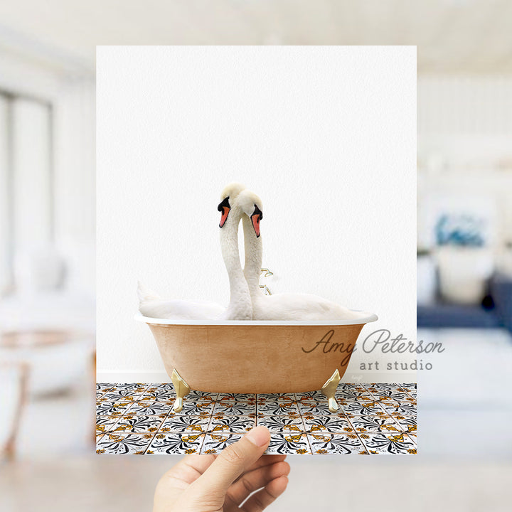 a person holding a card with a picture of two swans in a bathtub