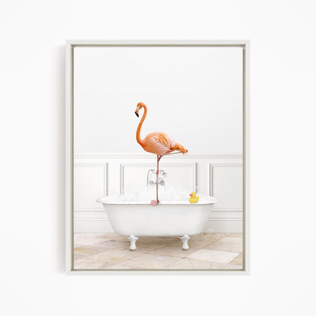 A vibrant flamingo stands on one leg in a white clawfoot bathtub, with a yellow rubber duck floating nearby.