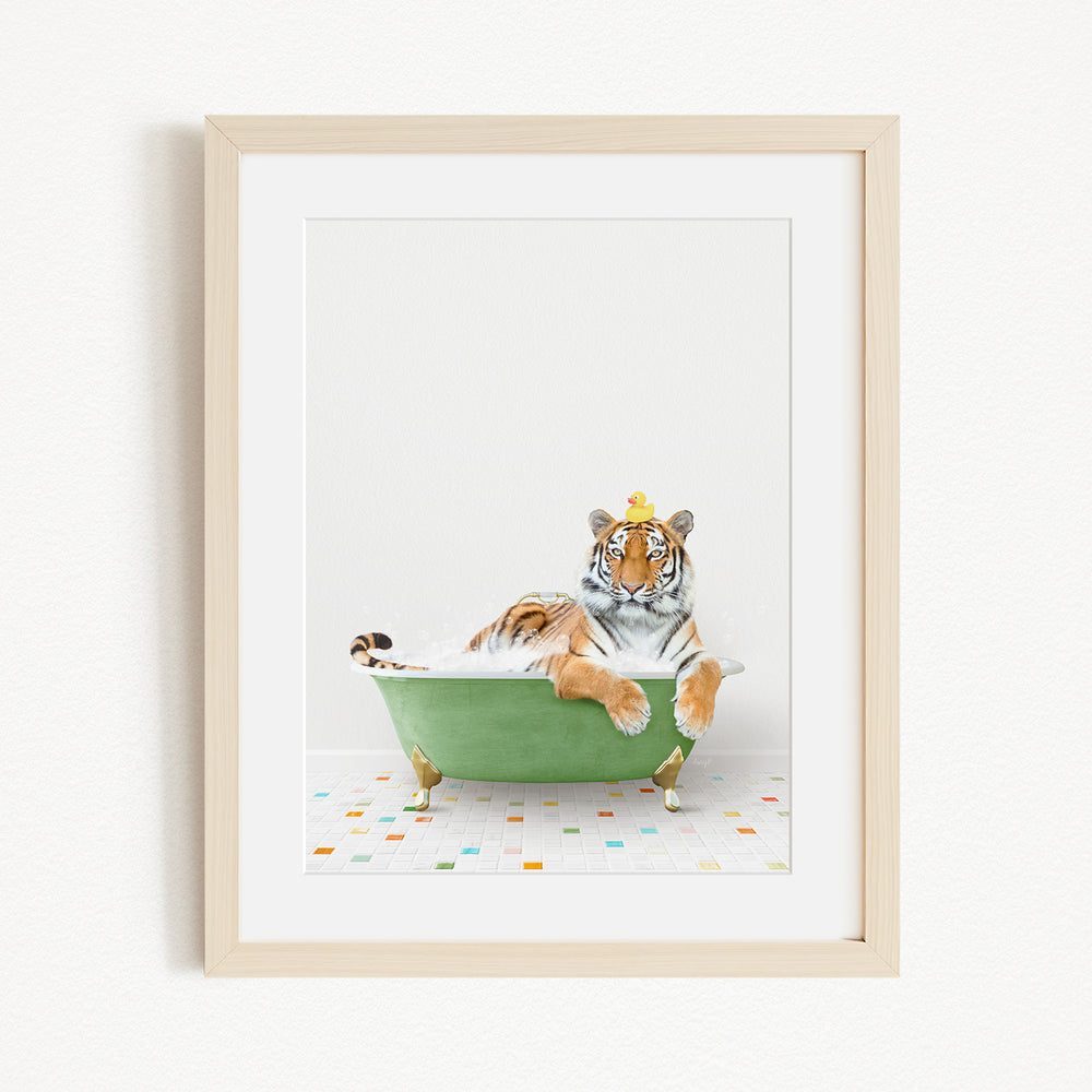 A tiger is sitting in a green bathtub, surrounded by colorful tiles on the floor.