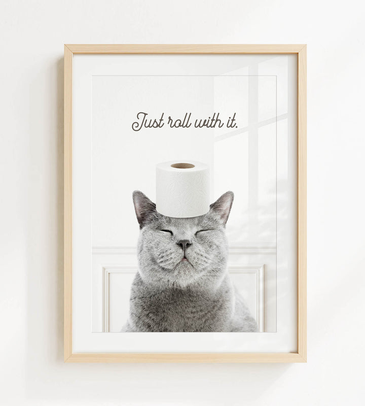 A gray cat with its eyes closed and a roll of toilet paper on its head, with the text "Just roll with it."