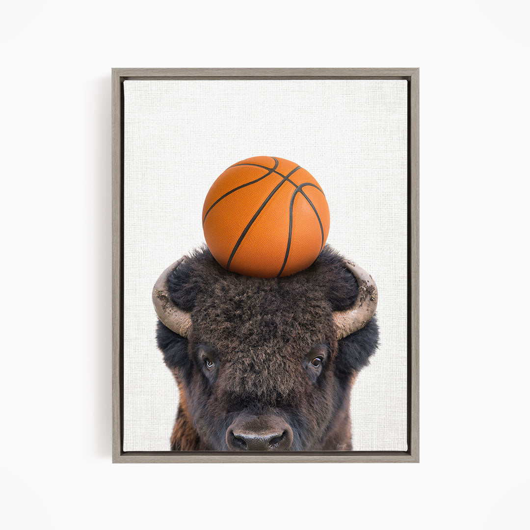 A buffalo with a basketball resting on its head.