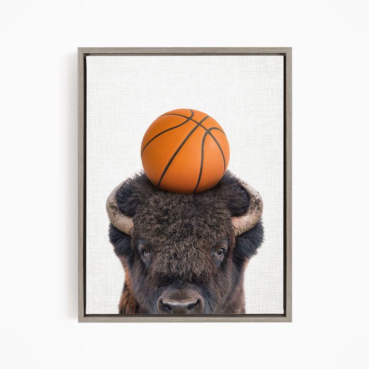 A buffalo with a basketball resting on its head.