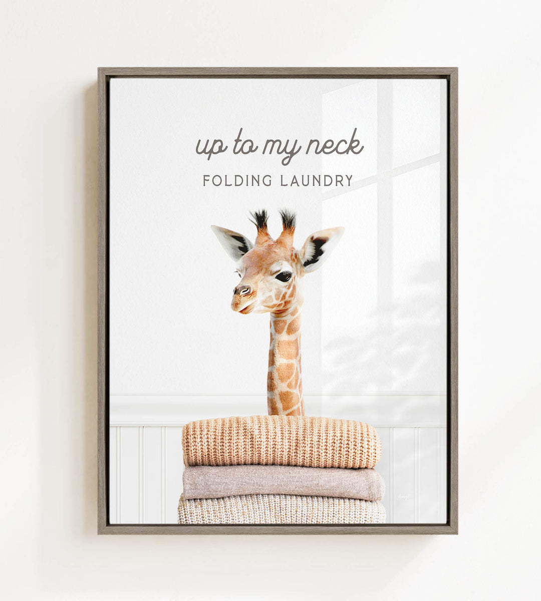 A giraffe standing on top of a stack of folded clothes, with the text "up to my neck" and "FOLDING LAUNDRY" displayed above the image.