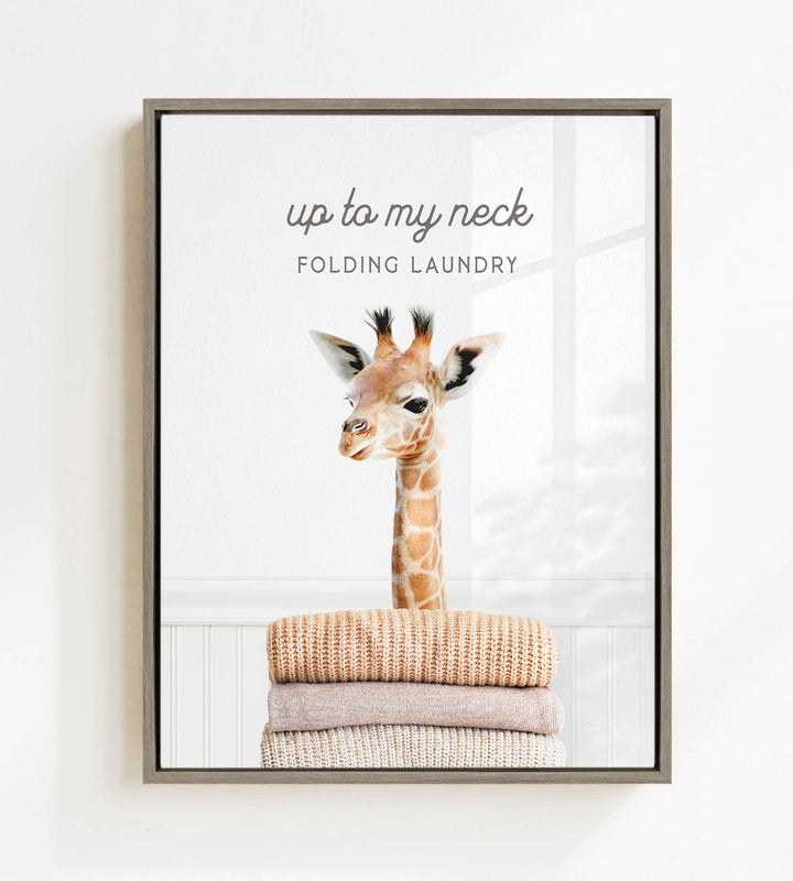 A giraffe standing on top of a stack of folded clothes, with the text "up to my neck" and "FOLDING LAUNDRY" displayed above the image.