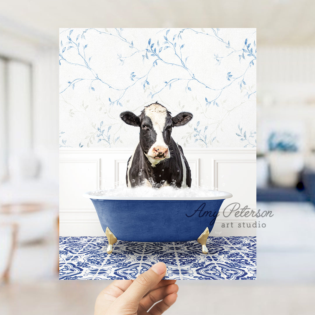 a hand holding up a card with a picture of a cow in a bathtub