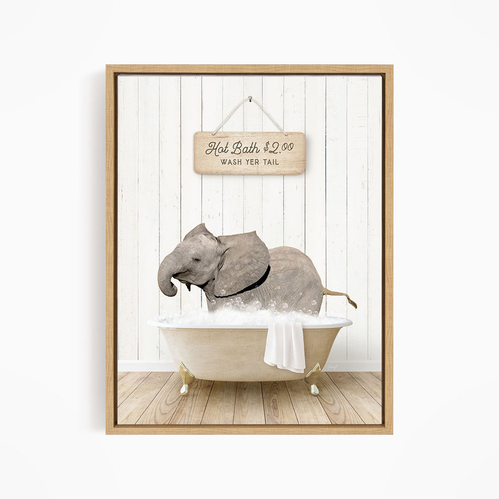A framed image depicting a gray elephant sitting in a bathtub filled with water, with a sign above the bathtub that reads "Hot Bath $2.00 WASH YER TAIL".