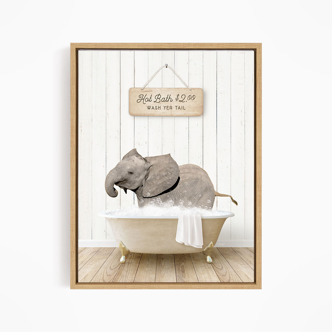 A framed image depicting a gray elephant sitting in a bathtub filled with water, with a sign above the bathtub that reads "Hot Bath $2.00 WASH YER TAIL".