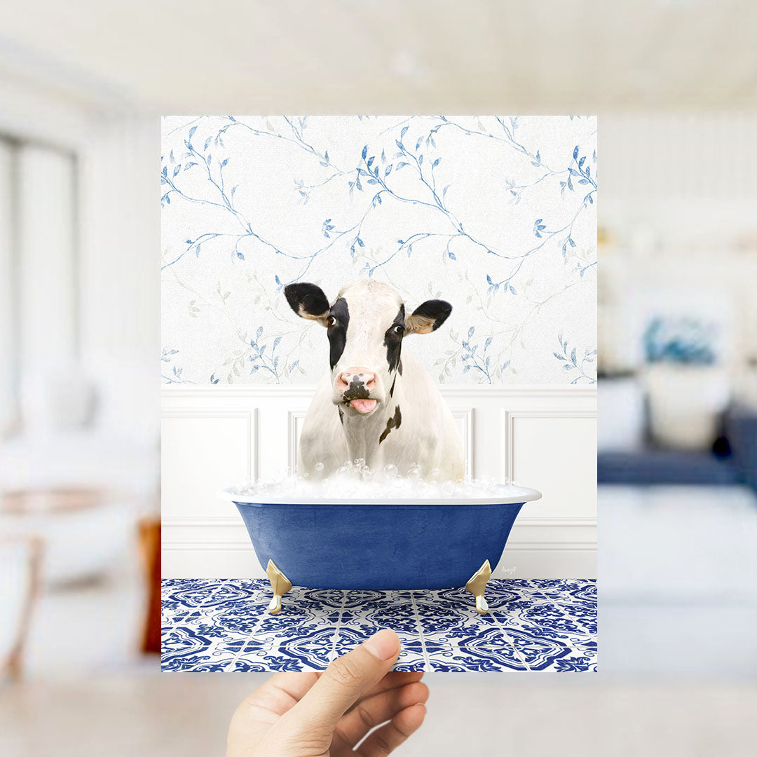 A cow is sitting in a blue bathtub filled with water, surrounded by a blue and white floral patterned wall.