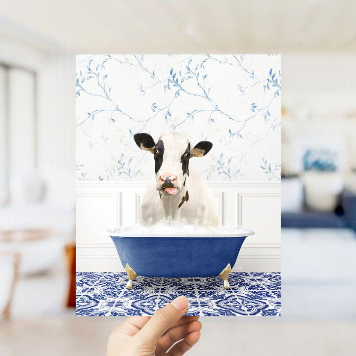 A cow is sitting in a blue bathtub filled with water, surrounded by a blue and white floral patterned wall.