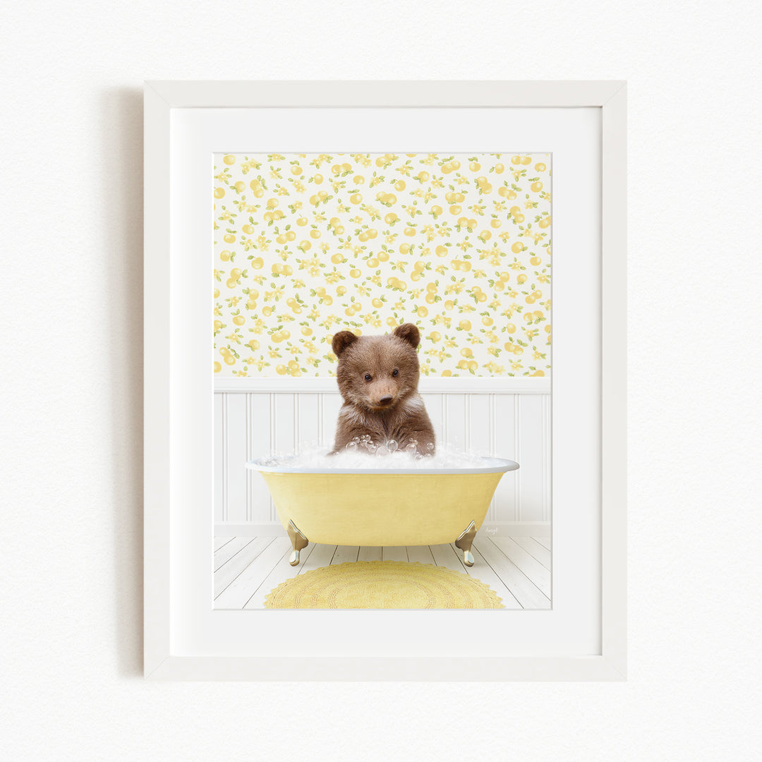 A cute brown bear sitting in a yellow bathtub filled with bubbles, surrounded by a yellow floral wallpaper.