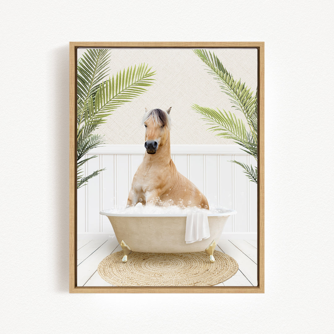 A light brown horse is sitting in a white bathtub filled with bubbles, surrounded by green palm leaves.