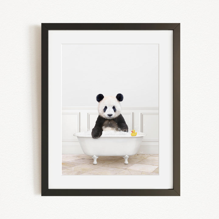 A panda bear sitting in a white bathtub, surrounded by a yellow rubber duck.