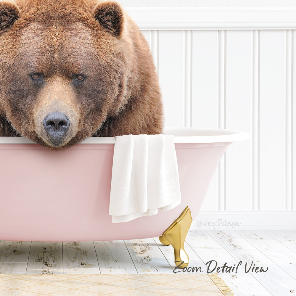 A large brown bear is sitting in a pink bathtub, with a towel and gold bathtub leg visible.