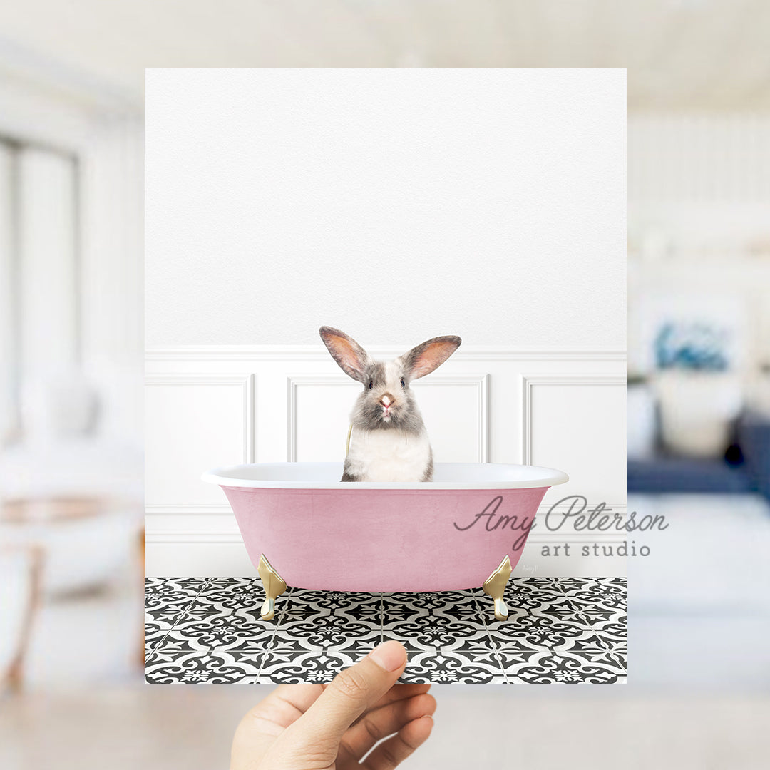 a person holding up a card with a picture of a bunny in a bathtub