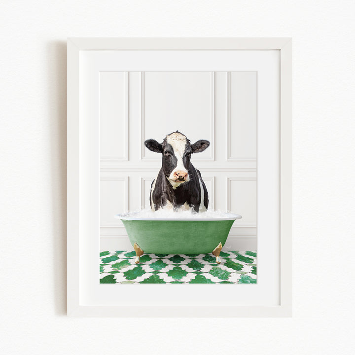 A black and white cow is sitting in a green bathtub filled with water, creating a whimsical and humorous scene.