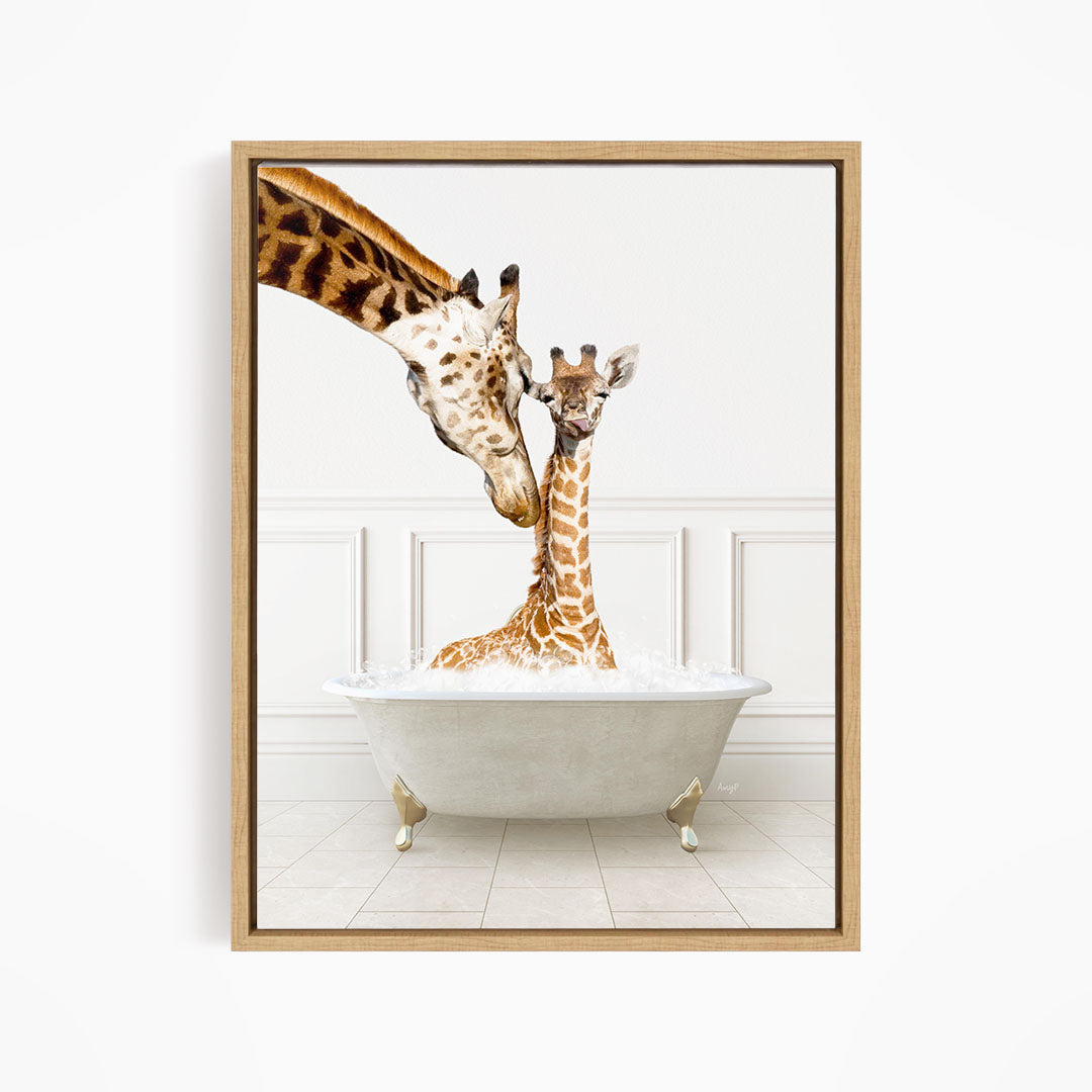 A mother giraffe and her baby giraffe are sitting together in a white bathtub, with the mother gently licking her baby.