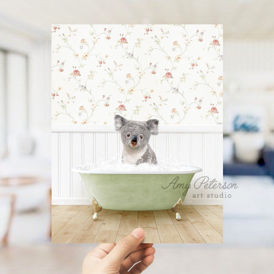 a hand holding a photo of a koala in a bathtub