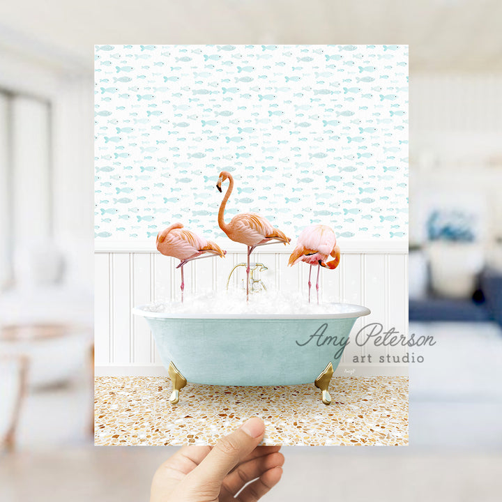 a person holding up a card with flamingos in a bathtub