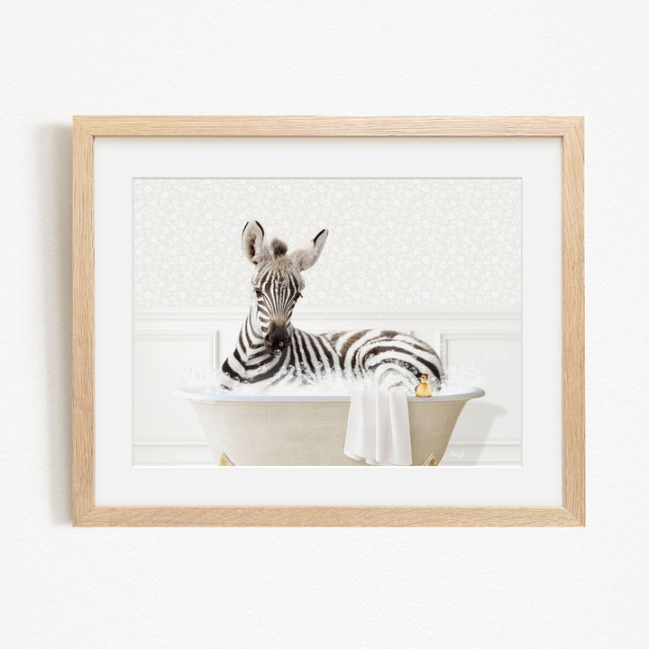 A zebra is sitting in a bathtub filled with water, surrounded by a towel and a rubber duck.