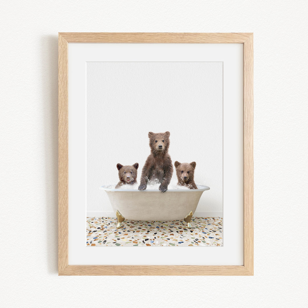 A framed image of three bears sitting in a bathtub, with one bear sitting in the center and the other two bears sitting on either side.