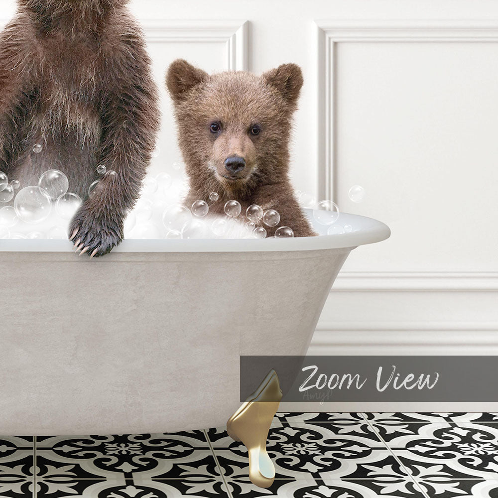 A baby bear sitting in a bathtub filled with bubbles, with a bathtub and a decorative tile floor visible in the background.