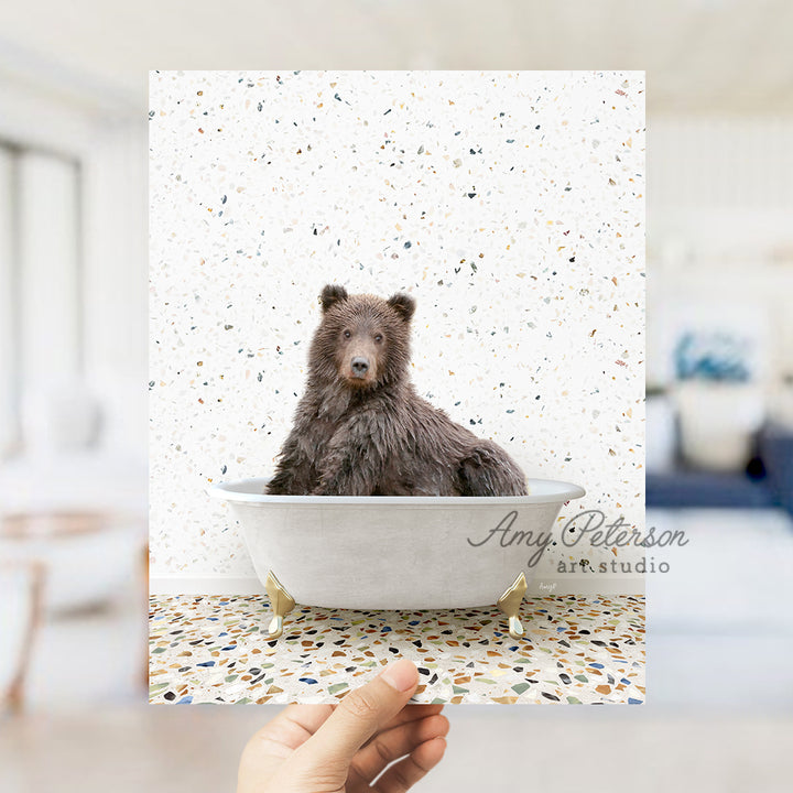 a hand holding up a card with a bear in a bathtub