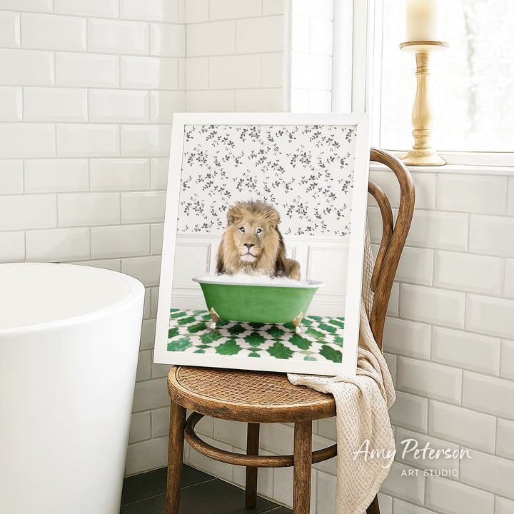 A framed image of a lion sitting in a green bathtub, surrounded by a patterned design, is displayed on a wooden chair in a bathroom setting.