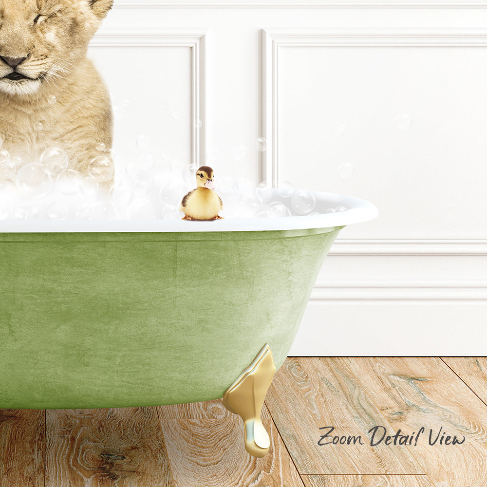 A lion cub is standing in a green bathtub filled with bubbles, while a small yellow duck sits on the edge of the tub.