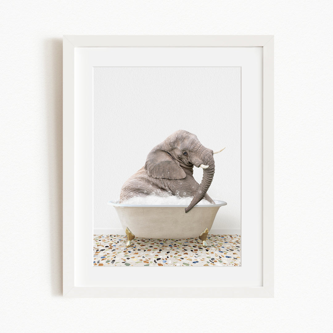 A gray elephant sitting in a white bathtub filled with water, with its trunk raised.