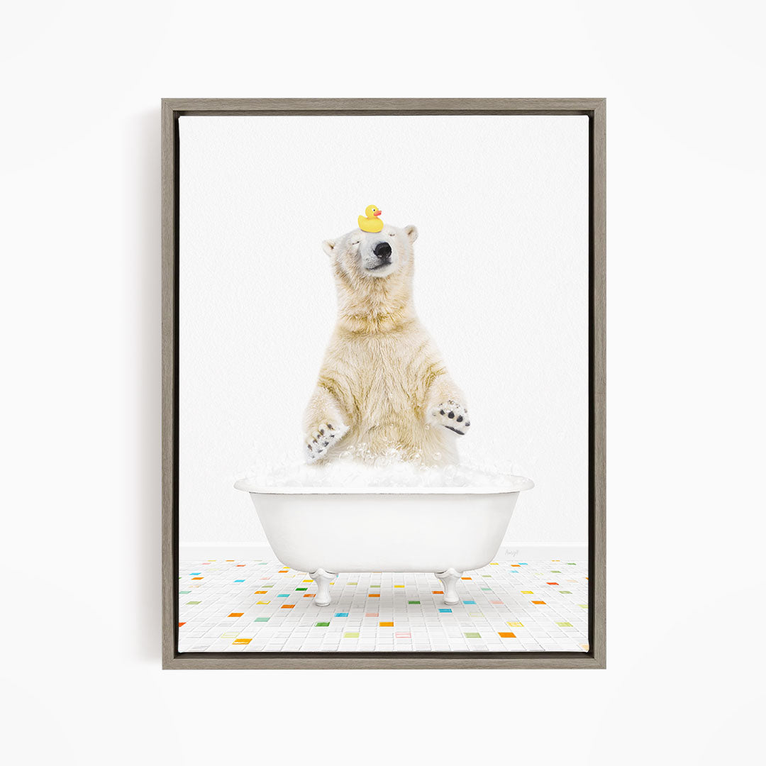 A polar bear is sitting in a white bathtub filled with bubbles, with a rubber duck perched on its head.