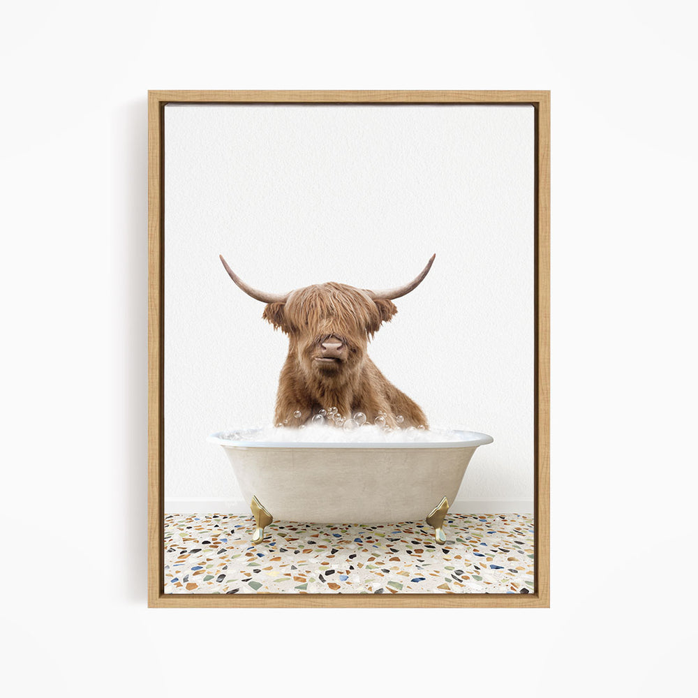 A Highland cow with long horns is sitting in a white bathtub filled with water, creating a whimsical and playful scene.