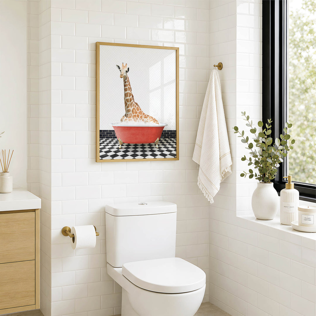 a bathroom with a white toilet, a framed picture of a giraffe in a red bathtub, and a towel hanging on the wall.