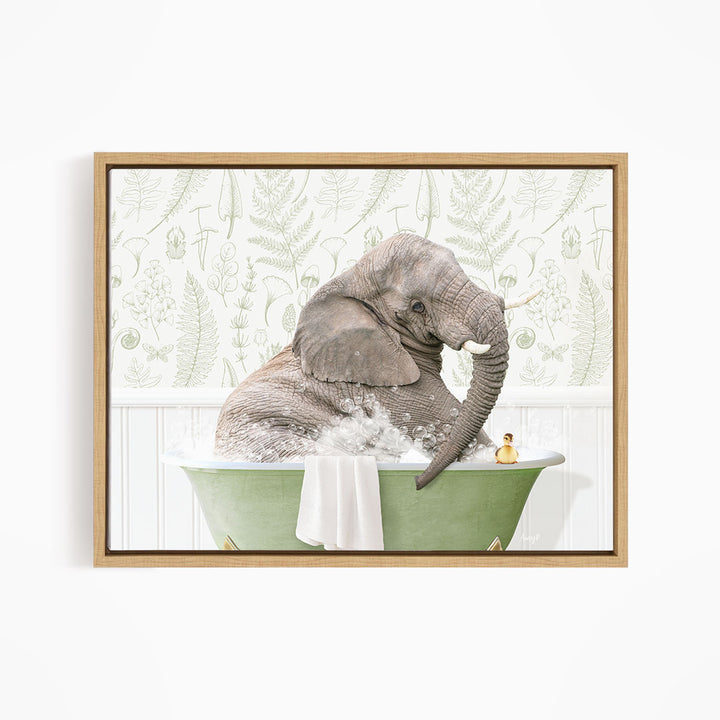 A gray elephant is sitting in a green bathtub filled with water, surrounded by a white towel and a small rubber duck.