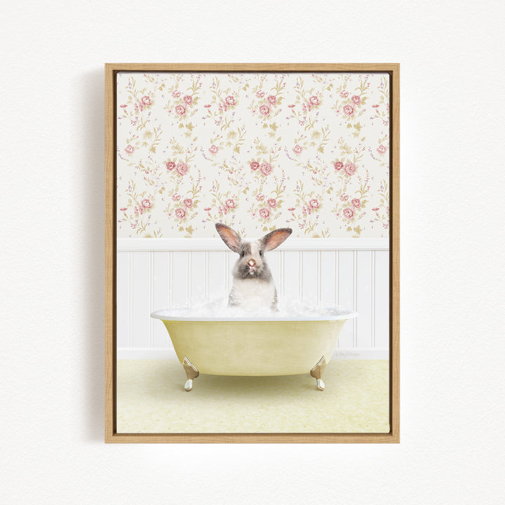 A small rabbit sitting in a yellow bathtub filled with water, surrounded by a floral wallpaper.