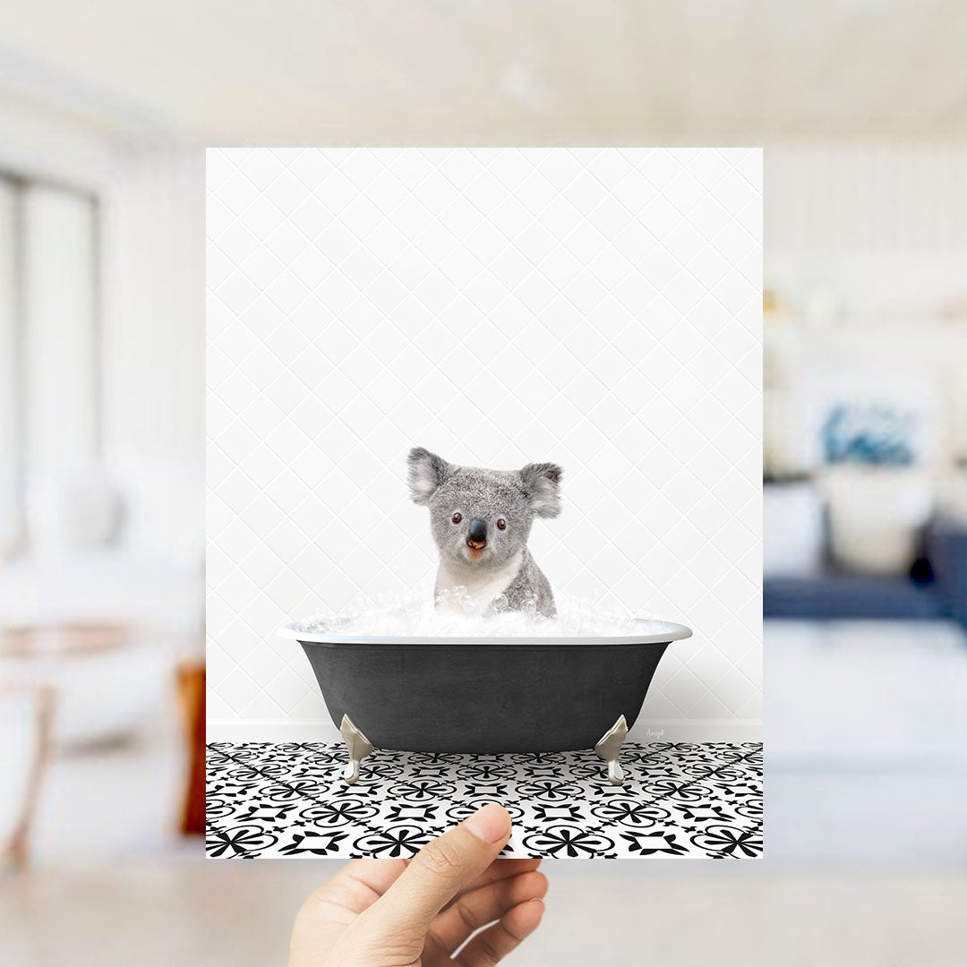 A koala bear sitting in a bathtub filled with water, looking at the camera.