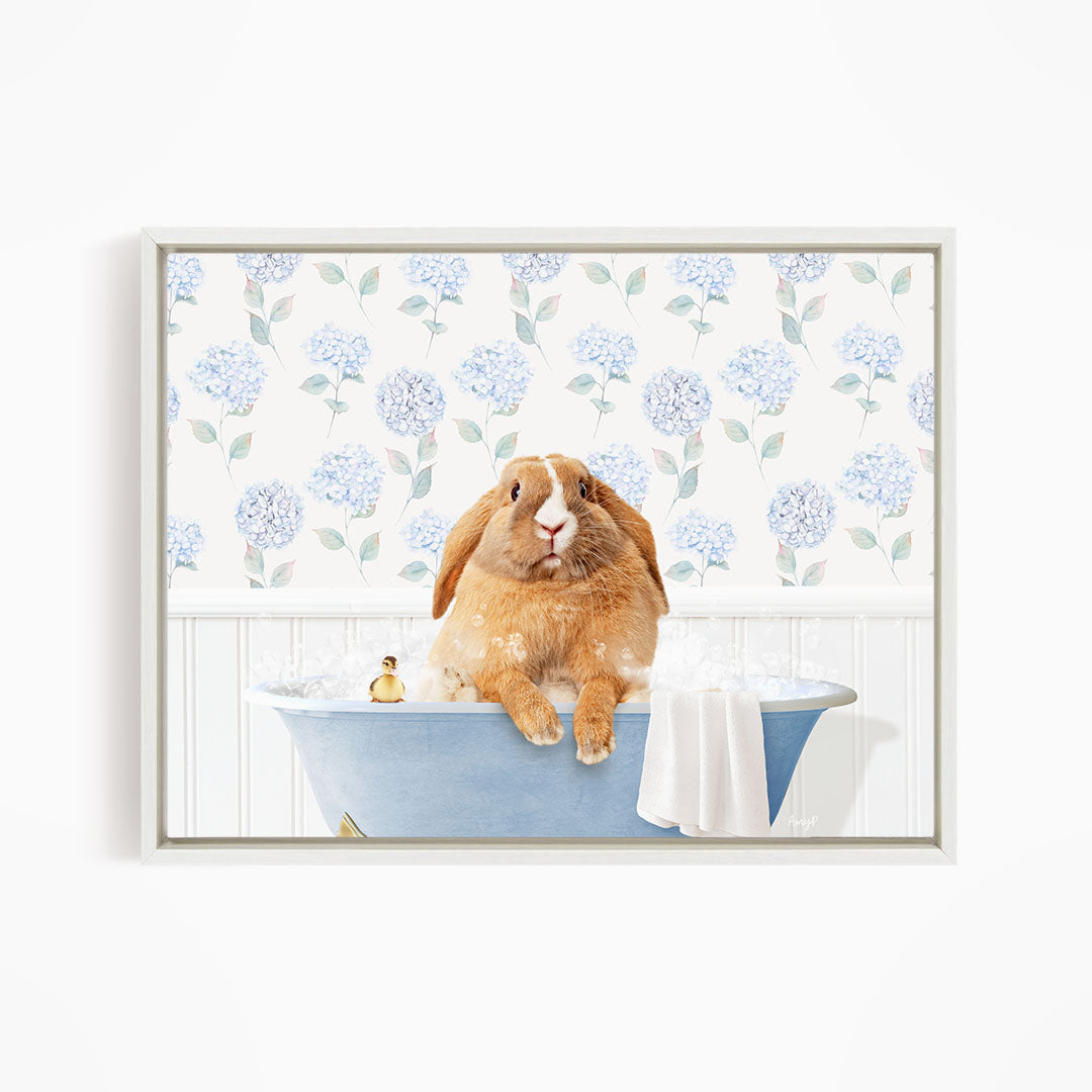 A brown rabbit sitting in a blue bathtub filled with water, surrounded by a floral patterned wall.