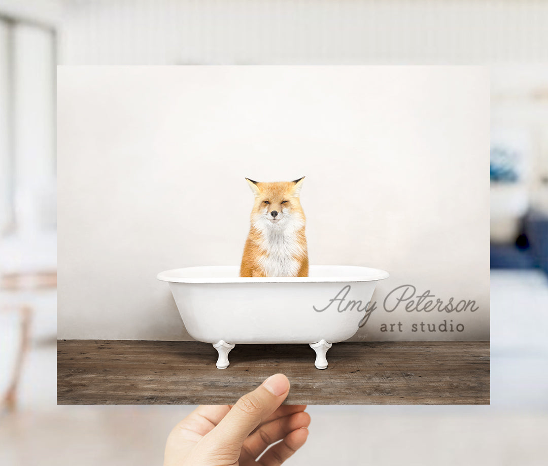 a hand holding up a card with a picture of a fox in a bathtub