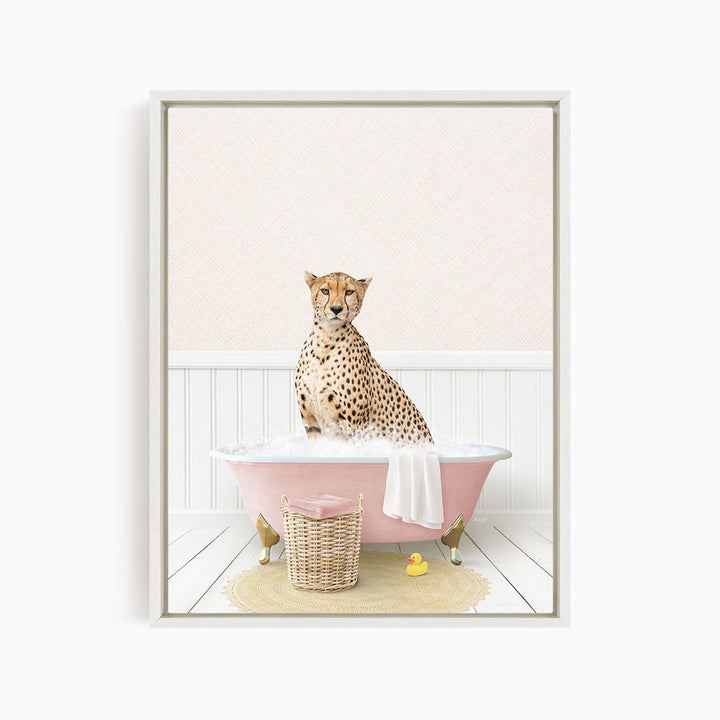 A cheetah sitting in a pink bathtub filled with bubbles, surrounded by a yellow rubber duck and a wicker basket.