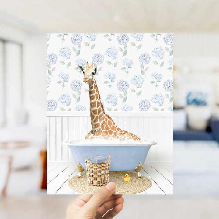 A giraffe sitting in a blue bathtub filled with water, surrounded by a wicker basket and a rubber duck.