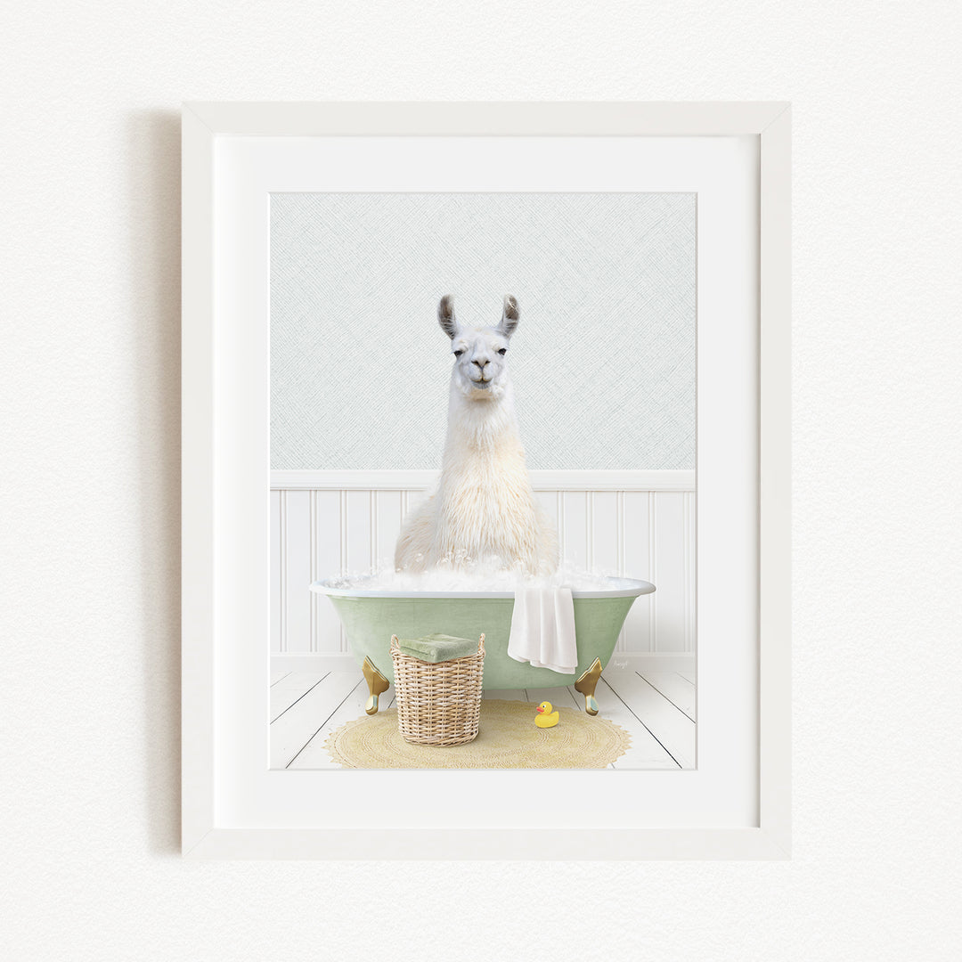 A white llama sitting in a green bathtub filled with bubbles, surrounded by a yellow rubber duck and a basket.