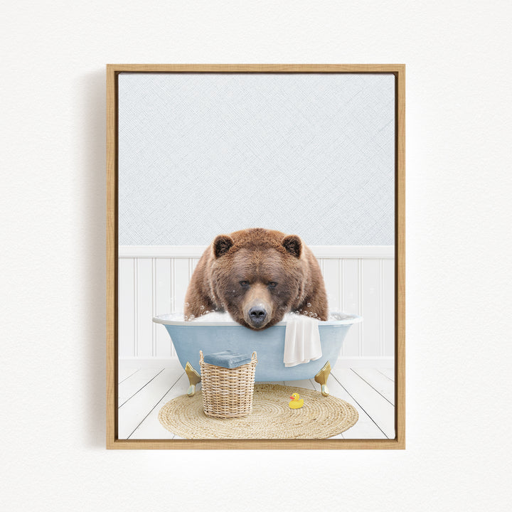 A brown bear is sitting in a blue bathtub, surrounded by a basket, a towel, and a rubber duck, creating a whimsical and playful scene.