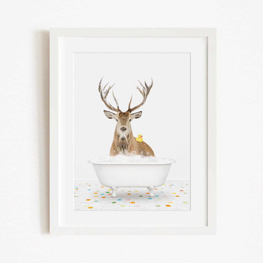 A deer with antlers is sitting in a white bathtub, with a yellow rubber duck perched on its head.