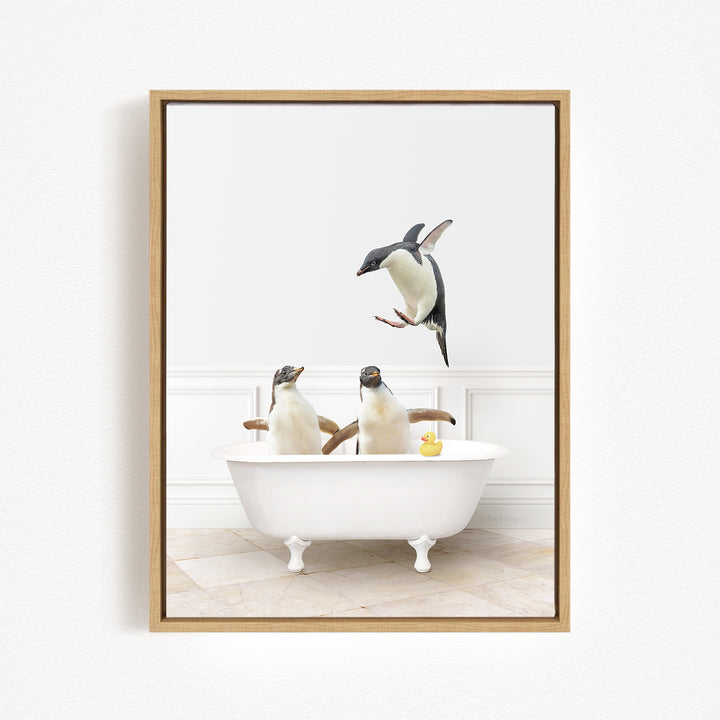A framed image depicting three penguins sitting in a white bathtub, with one penguin jumping out of the tub and another penguin sitting in the tub.