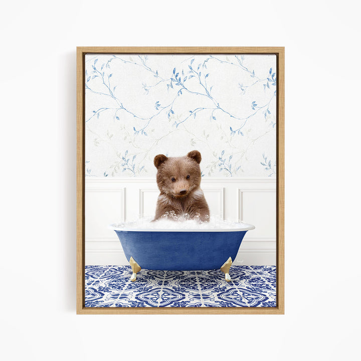 A brown bear sitting in a blue bathtub filled with bubbles, surrounded by a blue and white patterned rug and a floral wallpaper.