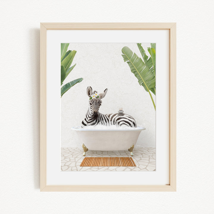 A zebra is sitting in a white bathtub, surrounded by green leaves, creating a whimsical and playful scene.