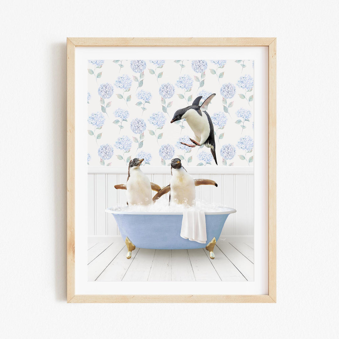 A framed image depicting two penguins sitting in a bathtub, with one penguin flying towards the other.