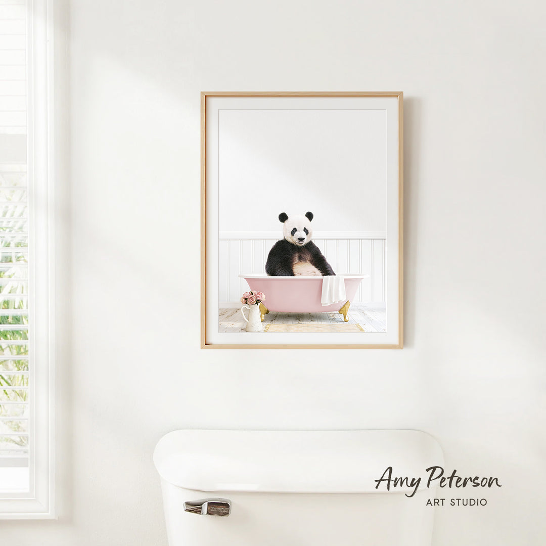 A panda bear sitting in a pink bathtub, with a vase of flowers and a white toilet nearby, is the focus of the image.